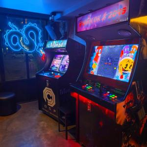 two video game machines in a room with lights at Cinematique Boutique Cinema Hotel in Bangkok