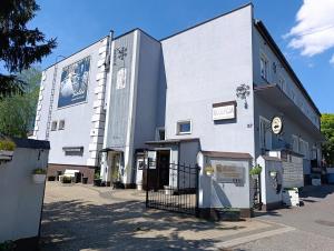 a white building with a sign on the side of it at Pensjonat Sielec in Sosnowiec