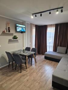 a living room with a table and chairs and a couch at Ferano Beach Apartments in Nesebar