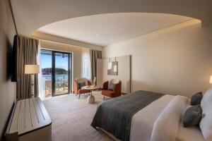 a hotel room with a bed and a table and chairs at Monte Mulini Adults Exclusive Hotel by Maistra Collection in Rovinj