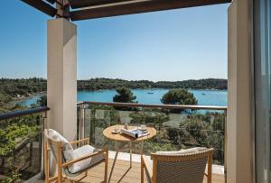 a balcony with a table and chairs and a view of the water at Monte Mulini Adults Exclusive Hotel by Maistra Collection in Rovinj +75 photos