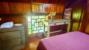 a bedroom with a bed and a window and a table at Loop Tribe - Social Hostel in Ha Giang