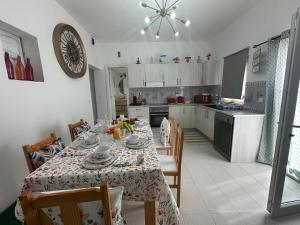 a dining room with a table and a kitchen at Ar Doce in Portel