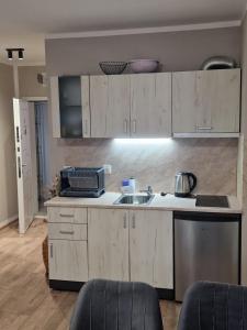 a kitchen with wooden cabinets and a sink in a room at Ferano Beach Apartments in Nesebar