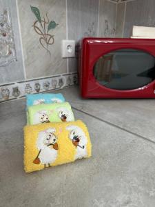 two towels with sheep on them next to a red microwave at Ar Doce in Portel