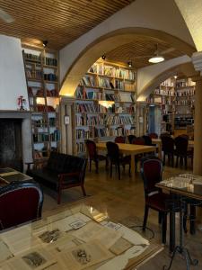 a library with chairs and tables and shelves of books at The Literary Man Obidos Hotel in Óbidos