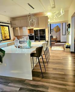 a kitchen with a large white counter and chairs at Luxe Apartments in Lusaka
