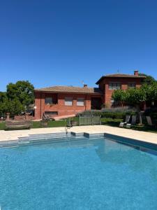 a large swimming pool in front of a house at Can Maximino in Ollers