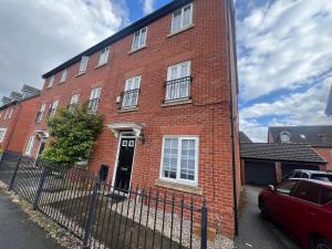 a red brick building with a black door at Favour homes in Manchester