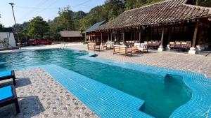 a swimming pool with chairs and a building at Loop Tribe - Social Hostel in Ha Giang