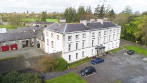 a large white building with cars parked in front of it at Rockfield House in Kells