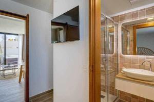 a bathroom with a sink and a mirror at Jable suites apartamentos de lujo en el centro in Corralejo +48 photos
