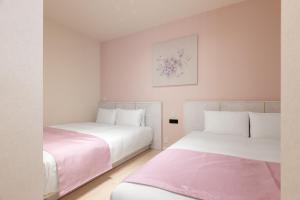 two beds in a room with pink and white at RHUMB LINE Tokyo in Tokyo