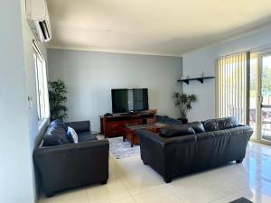 a living room with two leather couches and a flat screen tv at Unit 24 Seafront Estate in Jurien Bay