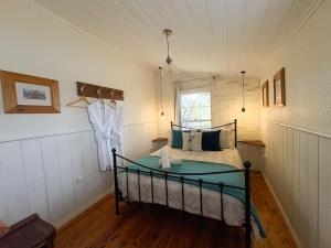 a bedroom with a bed and a suit hanging on a wall at Gladstone House in Beechworth