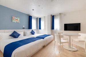 a bedroom with a large bed with a table and a tv at RHUMB LINE Tokyo in Tokyo