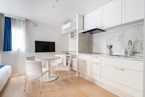 a kitchen with white cabinets and a table and chairs at RHUMB LINE Tokyo in Tokyo