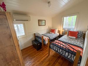 a small room with two beds and a chair at Gladstone House in Beechworth