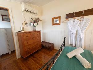 a bedroom with a bed and a dresser in a room at Gladstone House in Beechworth