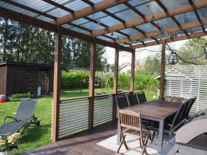 a wooden pergola with a wooden table and chairs at Villa Virtala Lohja in Lohja