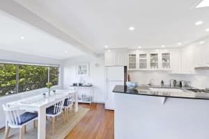 a kitchen with white cabinets and a table and chairs at Copa Dell - Stunning Views in Copacabana