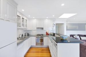 a white kitchen with white cabinets and a kitchen island at Copa Dell - Stunning Views in Copacabana