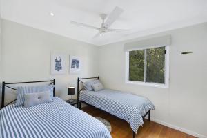 two beds in a white room with a ceiling fan at Copa Dell - Stunning Views in Copacabana