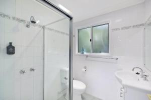 a white bathroom with a shower and a toilet at Copa Dell - Stunning Views in Copacabana +4 photos