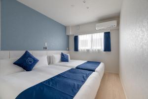 a bedroom with two beds with blue and white pillows at RHUMB LINE Tokyo in Tokyo +20 photos