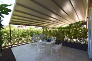 a patio with a table and chairs under awning at Appartamento EDEN - Clima, spazio esterno privato e parcheggio coperto in Marina di Campo