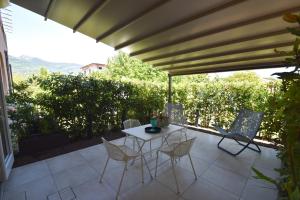 a patio with a table and chairs on a patio at Appartamento EDEN - Clima, spazio esterno privato e parcheggio coperto in Marina di Campo