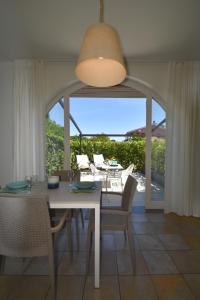 a dining room with a table and chairs and a window at Appartamento EDEN - Clima, spazio esterno privato e parcheggio coperto in Marina di Campo +33 photos