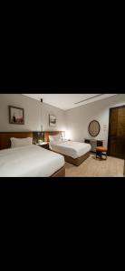 ein Hotelzimmer mit zwei Betten und einem Tisch in der Unterkunft ريف دنن in Al-'Ula