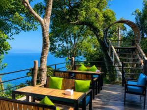 a deck with tables and chairs and the ocean at The Cliff Bungalow in Koh Rong Sanloem