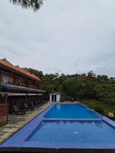 a large blue swimming pool next to a building at Teras Kaca in Bibis +11 photos