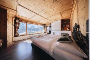 a large bed in a room with a large window at Villa Beaulieu in St. Moritz