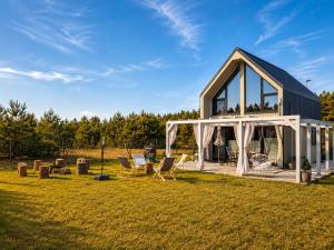 a house with a greenhouse and chairs in a field at Silvarium Kaszuby Domek Sosna in Stężyca