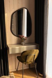 a mirror on a wall with a chair and a table at Zacisze Beskidu - Private House with Sauna, Jacuzzi & Pool in Łącko