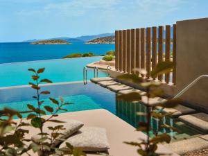 a swimming pool with a view of the water at Minos Palace Resort - Adults Only in Agios Nikolaos