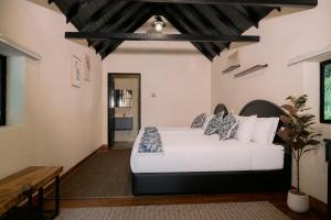 a bedroom with a white bed in a room at Rasah Golfers Cottage in Tanah Rata
