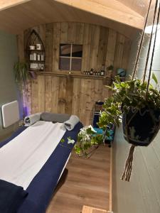 a room with a bed and potted plants in it at The Bru Bus in Maybole