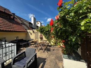 a patio with chairs and a fence and flowers at LH Hotel Golden Wheel in Prague