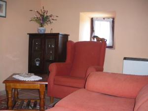 a living room with a couch and a chair and a table at Cuetu del Pradón in Piñeres