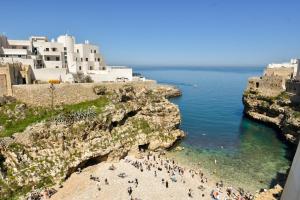 a group of people on a beach next to the ocean at Finisterre Casa di mare - Housea in Polignano a Mare