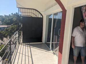 a man standing on the balcony of a house at Appartement VIDA 2 in Mahajanga