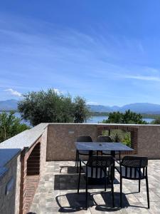 a table and chairs on a patio with a view at Emerald House Shiroke in Shkodër