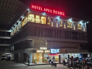 a hotel apex rooms building with people outside at night at Hotel Apex in Pilol
