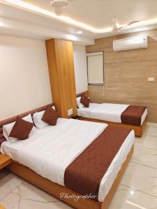 two beds in a hotel room with at Hotel Apex in Pilol