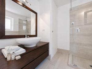 a bathroom with a sink and a mirror at Renew Terrace F with Swimming Pool 70m from the Beach in Baja Sardinia +19 photos