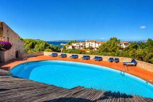 a swimming pool with lounge chairs and a view at Renew Terrace F with Swimming Pool 70m from the Beach in Baja Sardinia